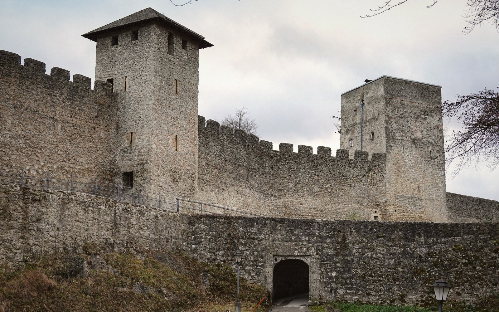 Stone castle walls with crenellated battlements and two square watchtowers